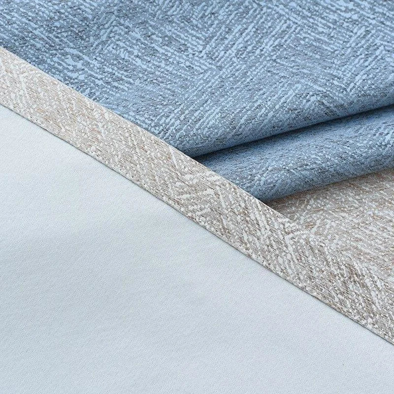 Image de tissus superposés, présentant un motif texturé en bleu et beige, idéal pour la décoration intérieure et l'ameublement. Parfait pour ajouter une touche élégante et contemporaine à vos projets de design d'intérieur.