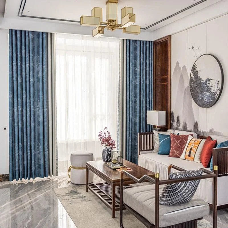 Salon élégant avec rideaux bleus, décoration murale artistique et mobilier raffiné. Ambiance sophistiquée avec un canapé agrémenté de coussins colorés, une table basse moderne, et un lustre design doré. Espace lumineux et accueillant, idéal pour un intérieur contemporain et harmonieux. Choix parfait pour un décor subtil et esthétiquement plaisant.