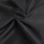 Drapé élégant de tissu noir offrant un pli fluide et raffiné, idéal pour la confection de vêtements chics et intemporels, parfait pour une garde-robe sophistiquée.