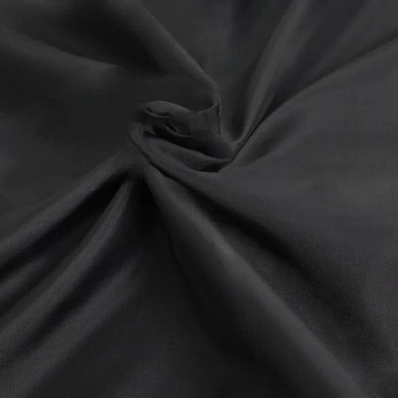Drapé élégant de tissu noir offrant un pli fluide et raffiné, idéal pour la confection de vêtements chics et intemporels, parfait pour une garde-robe sophistiquée.