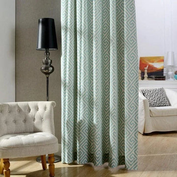 Rideau moderne avec motif géométrique dans un intérieur élégant, accompagné d'un fauteuil confortable et d'une lampe design, idéal pour sublimer votre salon.