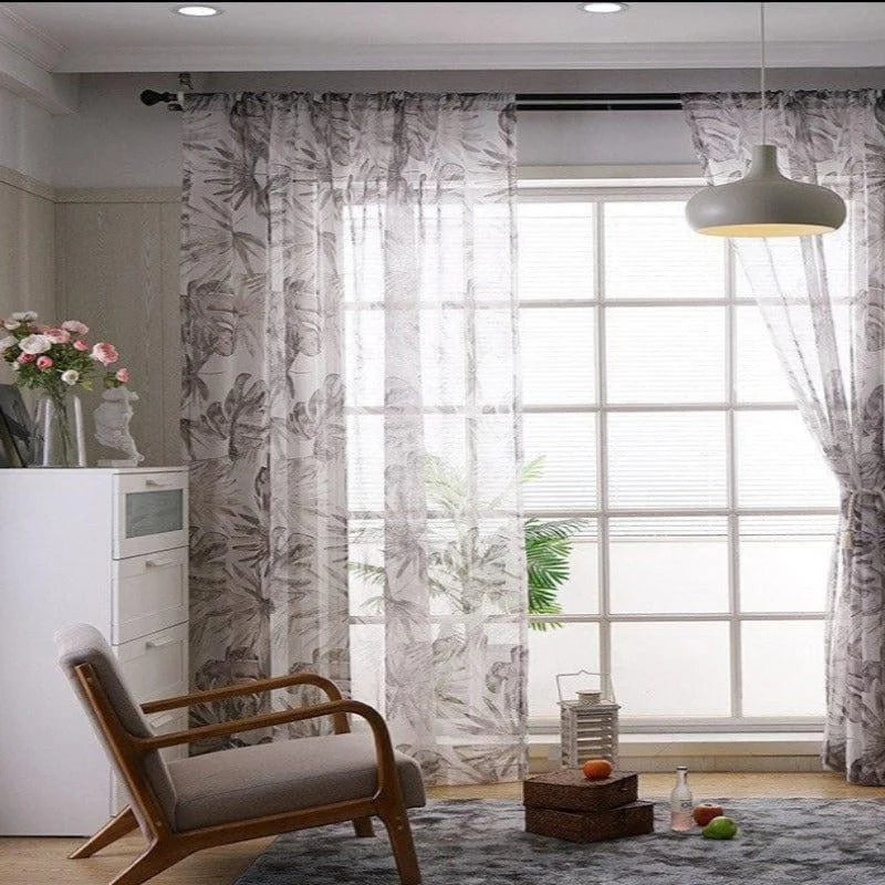 Rideaux légers à motif feuillage pour salon, créant une ambiance lumineuse et élégante. Parfait pour ajouter une touche déco moderne à votre intérieur. Idéal pour une grande fenêtre, offrant intimité et style. Complète joliment un fauteuil rétro et un éclairage suspendu design.