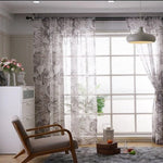 Rideaux légers à motif feuillage pour salon, créant une ambiance lumineuse et élégante. Parfait pour ajouter une touche déco moderne à votre intérieur. Idéal pour une grande fenêtre, offrant intimité et style. Complète joliment un fauteuil rétro et un éclairage suspendu design.