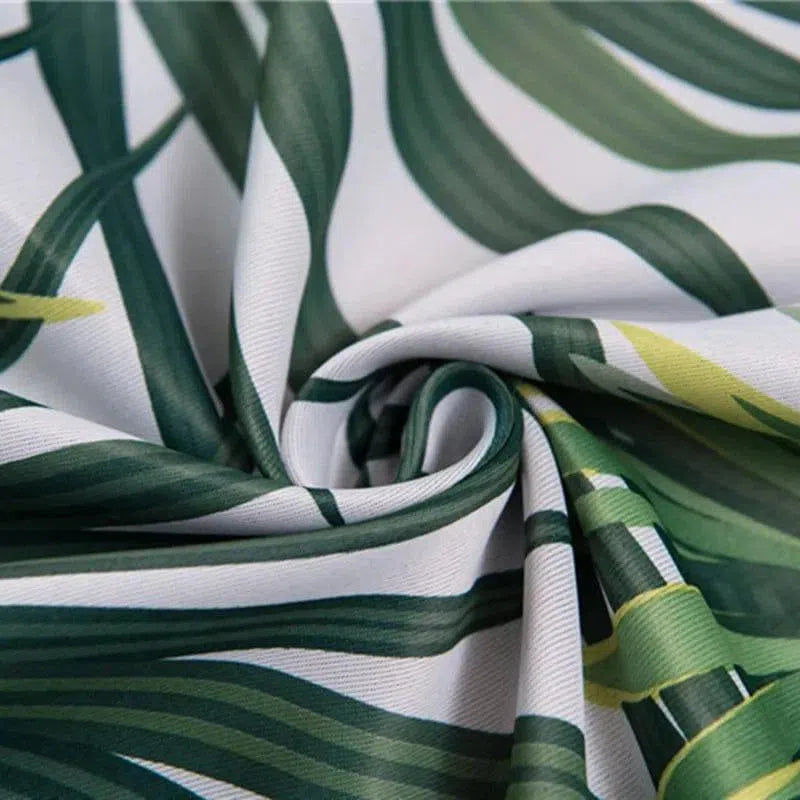 Image montrant un tissu avec un motif de feuilles tropicales vertes sur fond clair, idéal pour une décoration intérieure exotique, ajoutant une touche naturelle et chic à tout espace de vie.
