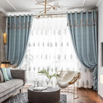 Rideaux élégants pour salon moderne avec motif végétal, offrant une ambiance lumineuse et raffinée. Décoration intérieure comprenant canapé contemporain, table basse design, et fauteuil confortable pour un espace de vie chic et accueillant.