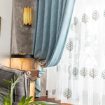 Rideau moderne et élégant en bleu, parfait pour ajouter une touche de sophistication à votre salon. Motifs d'arbres sur voilage transparent pour une ambiance naturelle et apaisante. Idéal pour la décoration intérieure contemporaine et l'optimisation de la lumière dans la pièce. Accessoire de maison stylé compatible avec différents styles de décoration.
