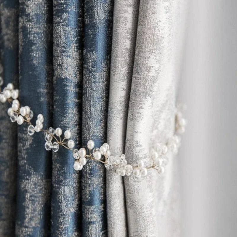 Rideaux élégants en deux tons bleu et gris clair, ornés d'un embrasse décorative avec des perles et cristaux, ajoutant une touche de sophistication à votre intérieur. Idéal pour salon ou chambre, ce style chic rehaussera votre décoration avec raffinement. Optimisation de l'espace avec une ambiance chaleureuse et accueillante.