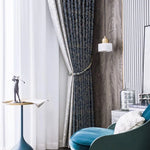Rideaux élégants dans un salon moderne, créant une ambiance chic et raffinée. Ce décor met en valeur un fauteuil confortable avec une teinte bleue apaisante, une table d'appoint moderne avec une sculpture artistique, et un éclairage pendulaire qui apporte une touche sophistiquée à l'ensemble du design intérieur. Parfait pour améliorer l'esthétique de votre espace de vie.