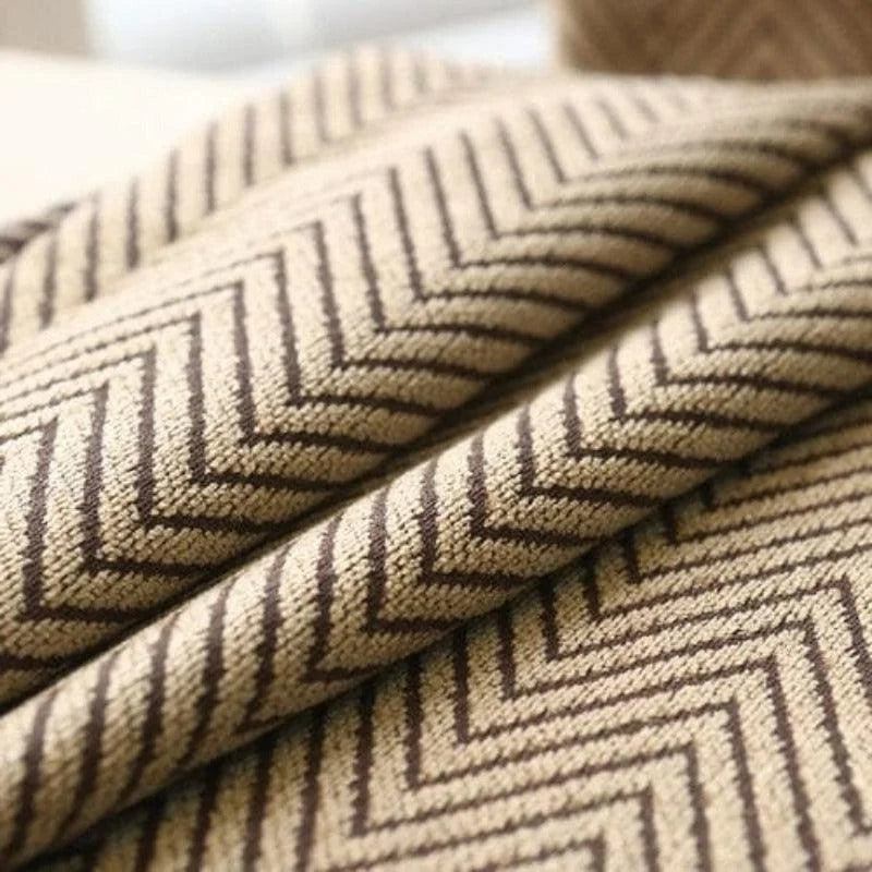 Élégant tissu beige à motifs chevrons pour décoration intérieure, parfait pour donner une touche moderne et chic à votre espace de vie. Design sophistiqué pour rideaux ou coussins.