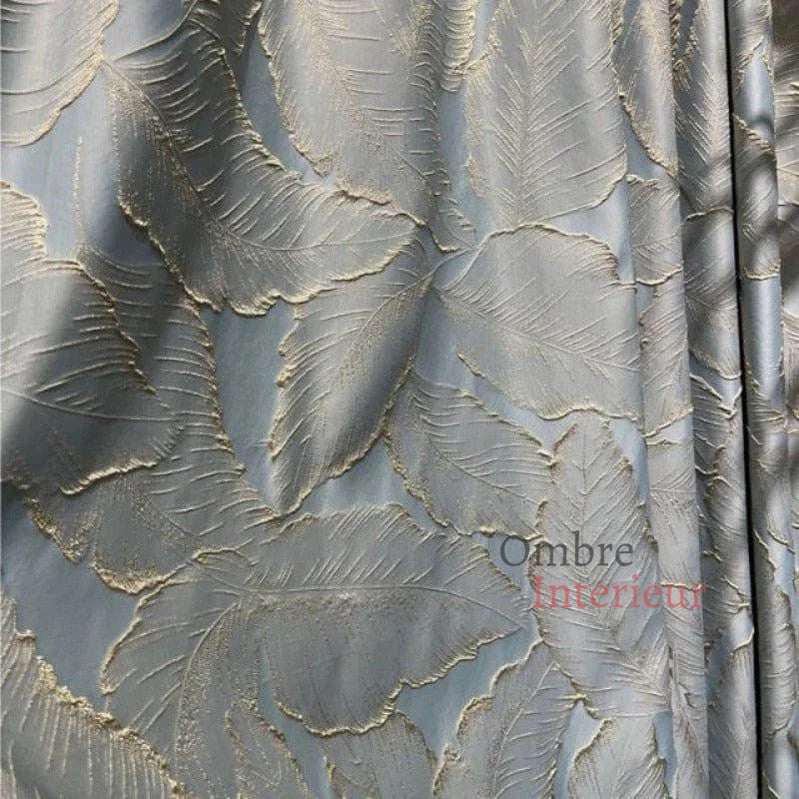 Rideau brodé élégant avec motif de feuilles dorées sur fond bleu gris, idéal pour un salon raffiné. Tissu de haute qualité, parfait pour ajouter une touche de luxe et de chaleur à votre intérieur.