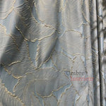 Rideau brodé élégant avec motif de feuilles dorées sur fond bleu gris, idéal pour un salon raffiné. Tissu de haute qualité, parfait pour ajouter une touche de luxe et de chaleur à votre intérieur.