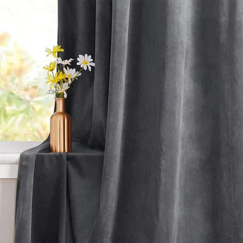 Rideau gris élégant installé près d'une fenêtre, avec un vase doré contenant un bouquet de fleurs blanches et jaunes. Accessoire de décoration intérieure sophistiqué pour un salon moderne. Rideau occultant idéal pour réguler la lumière naturelle et ajouter une touche de style contemporain.