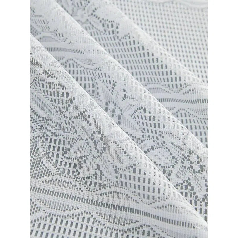 Voile blanc délicatement ajouré, idéal pour rideaux élégants et décoration intérieure chic. Design raffiné et motif orné, parfait pour ajouter une touche de sophistication à votre espace de vie avec style.