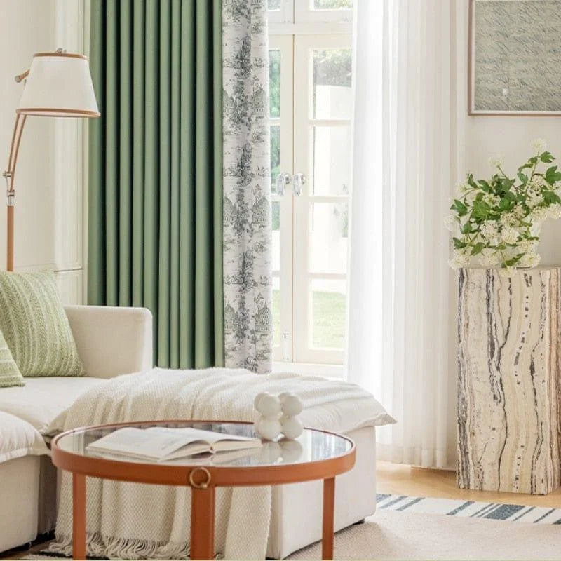Salon élégant avec canapé beige et coussin vert, table basse ronde avec livre et décoration moderne, lampadaire design, rideaux vert olive et motif toile, fenêtre lumineuse avec rideaux blancs, vase floral sur table d'appoint, ambiance chaleureuse et accueillante pour une décoration intérieure sophistiquée.
