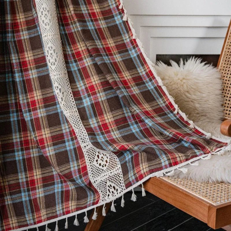 Plaid à carreaux multicolores avec bordure de dentelle, idéal pour une décoration de salon chaleureuse et élégante. Coussin moelleux en arrière-plan ajoutant du confort. Ambiance cosy et accueillante parfaite pour les soirées d'hiver.
