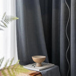 Rideaux élégants et modernes de couleur sombre, parfaits pour créer une ambiance sophistiquée et accueillante dans votre salon ou chambre. Idéal pour une décoration intérieure chic et contemporaine. Accessoirisé avec des éléments décoratifs comme un bol minimaliste sur une table aux lignes épurées.