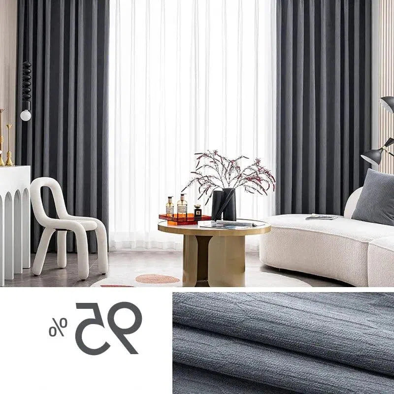 Salon moderne avec rideaux occultants gris foncé, ajoutant une touche élégante à la décoration intérieure. Mobilier contemporain comprenant un canapé confortable et une table basse au design unique. Ambiance lumineuse grâce aux voilages blancs, parfaitement intégrée dans un intérieur design et sophistiqué. Idéal pour un agencement chic et moderne.