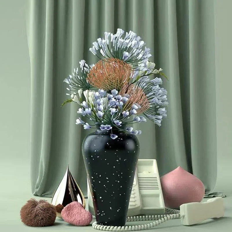 Vase décoratif noir avec motifs blancs, agrémenté d'un élégant bouquet de fleurs dans des tons pastel. Idéal pour sublimer un intérieur moderne. Accessoires vintage en arrière-plan, incluant un téléphone rétro et des éléments décoratifs contemporains. Ambiance chic et tendance pour un espace à la fois classique et sophistiqué.