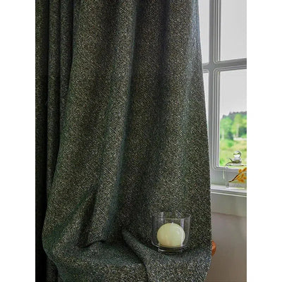 Rideau épais gris foncé drapé dans un intérieur lumineux, accentuant l'élégance d'une pièce. Accessoire déco avec bougie dans son support en verre, créant une ambiance chaleureuse près de la fenêtre ouverte avec vue sur un paysage verdoyant. Idéal pour ajouter une touche sophistiquée à votre salon ou chambre.