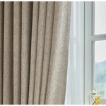 Rideau élégant beige devant une fenêtre, idéal pour le salon ou la chambre. Offre une isolation lumineuse optimale et ajoute une touche de sophistication à votre intérieur. Solution pratique pour améliorer l'ambiance de votre maison.