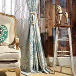 Rideau bleu à motifs élégants dans un salon au design vintage, avec un cheval en bois sur tabouret et un fauteuil confortable. Ambiance chaleureuse et esthétique raffinée pour une décoration intérieure chic.