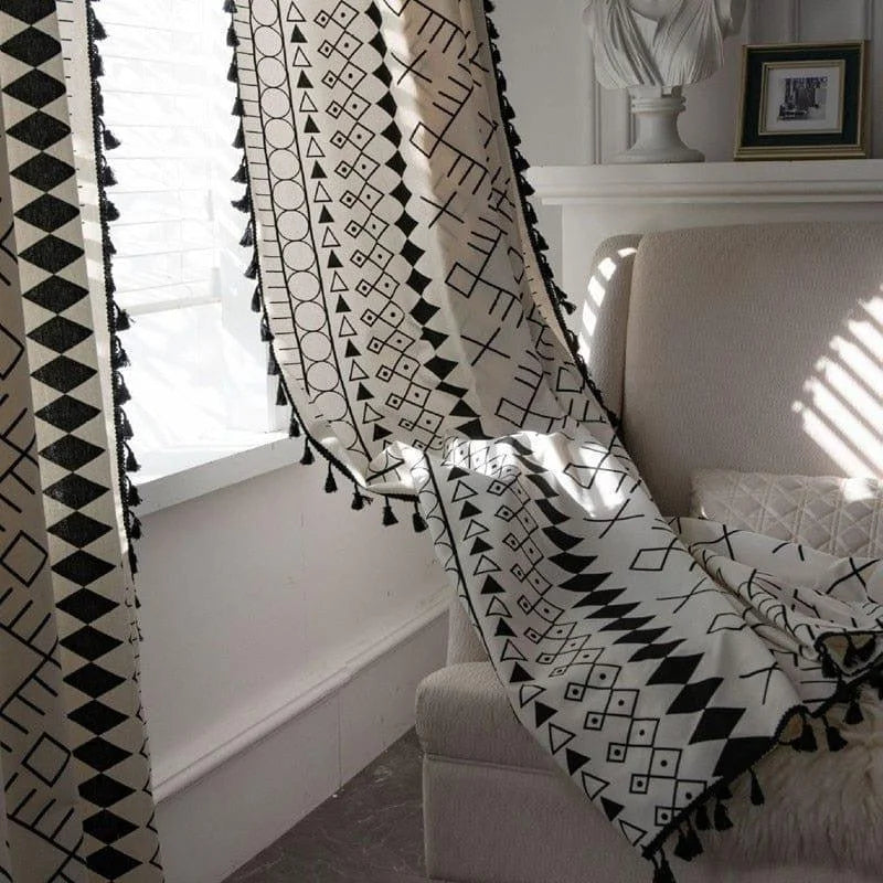 Rideau bohème chic avec motifs géométriques noirs et blancs, parfait pour embellir un salon moderne. Ses franges élégantes ajoutent une touche d'originalité à la décoration intérieure. Idéal pour filtrer la lumière tout en créant une ambiance apaisante et stylée.