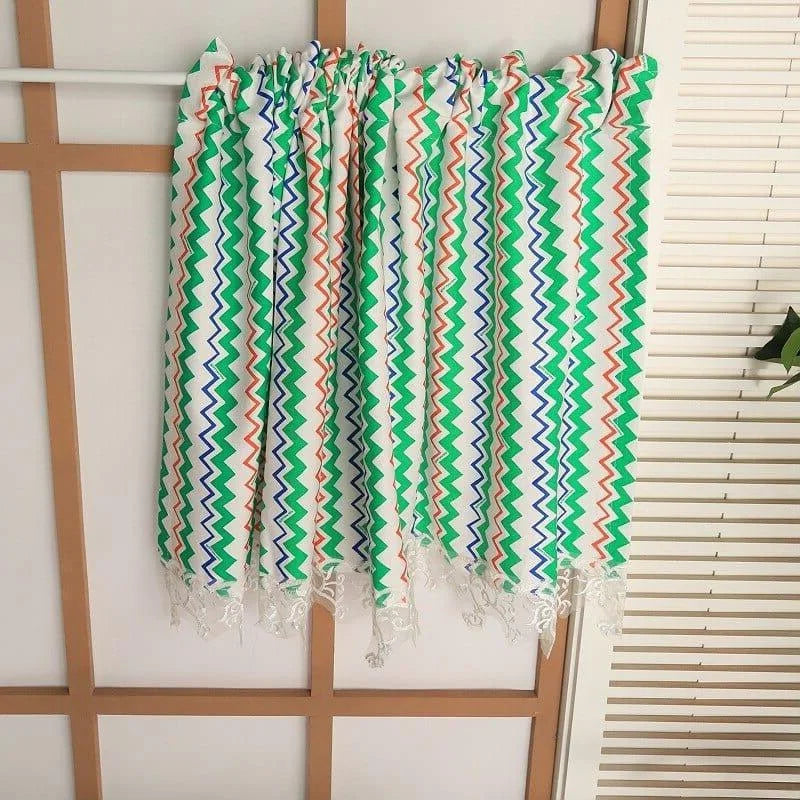 Écharpe colorée avec motifs zigzag multicolores verts, bleus et orangés, idéale pour ajouter une touche de vitalité à votre tenue printanière ou estivale. Accessoire de mode moderne et tendance pour toutes les occasions.