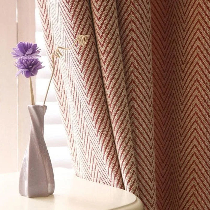Rideau avec motif chevrons rouges et blancs suspendu près d'un vase décoratif avec des fleurs violettes, ajoutant une touche élégante et moderne à tout intérieur. Idéal pour une décoration de salon ou de chambre.