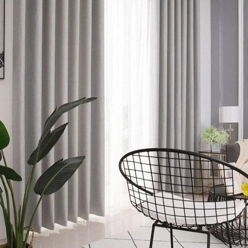 Rideaux opaques gris modernes dans un salon élégant, parfaits pour créer une ambiance chaleureuse et intime. Solution idéale pour ajouter une touche contemporaine à votre décoration intérieure.