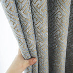 Rideau à motif géométrique gris et doré, parfait pour une décoration intérieure moderne et élégante. Accessoire idéal pour habiller vos fenêtres avec style et sophistication.