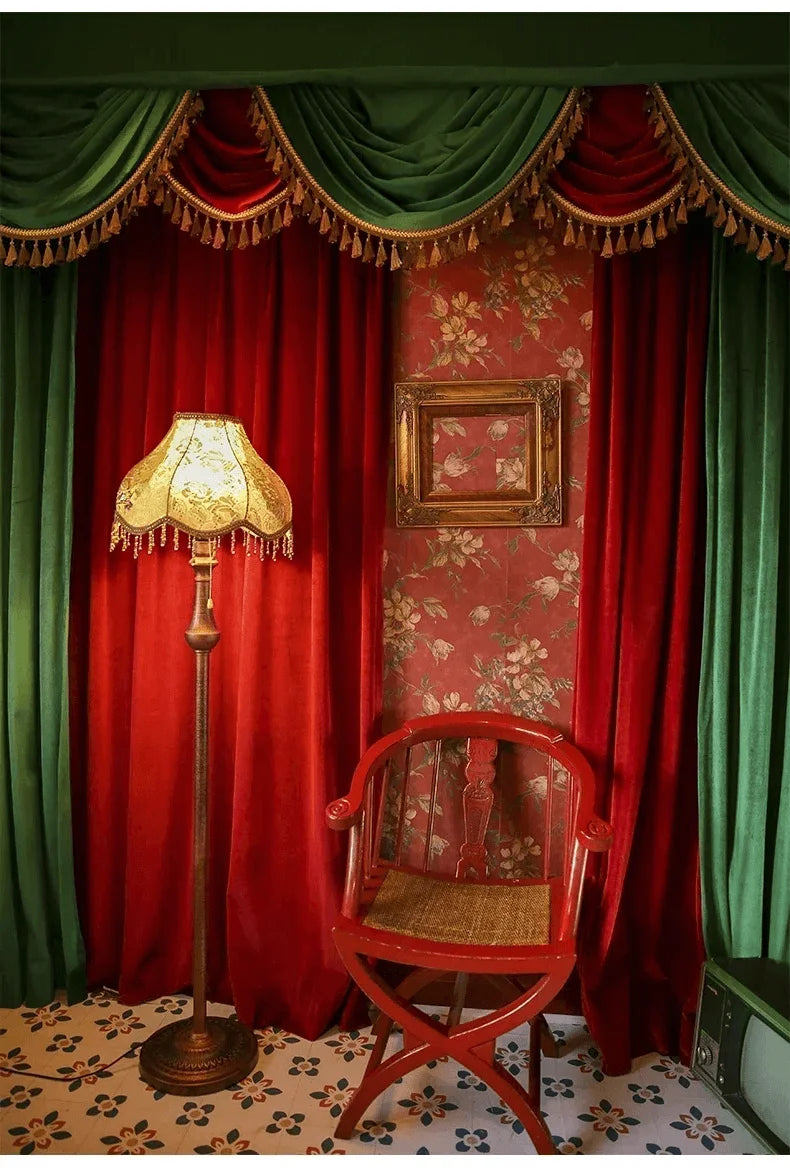 Rideau luxueux en velours rouge et vert avec franges dorées pour décoration intérieure élégante. Ambiance rétro chic avec lampe vintage et chaise en bois rouge. Parfait pour un salon sophistiqué ou un théâtre privé. Design floral sur papier peint pour une touche artistique intemporelle.