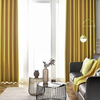 Salon élégant avec rideaux jaunes, canapé foncé, et tables basses modernes. L'ambiance est contemporaine et chaleureuse grâce à l'éclairage naturel diffusé par la grande fenêtre. Accessoires décoratifs comme le vase et le plaid ajoutent une touche de confort au décor. Idéal pour un espace de vie moderne et accueillant.