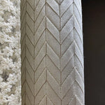 Tissu élégant avec motif chevron beige, parfait pour décoration intérieure moderne. Design sophistiqué, idéal pour rideaux ou ameublement. Comprend également un motif floral en relief pour une touche raffinée. Convient aux espaces de vie contemporains et classiques.
