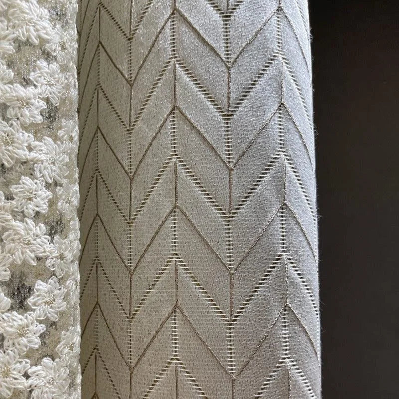 Tissu élégant avec motif chevron beige, parfait pour décoration intérieure moderne. Design sophistiqué, idéal pour rideaux ou ameublement. Comprend également un motif floral en relief pour une touche raffinée. Convient aux espaces de vie contemporains et classiques.