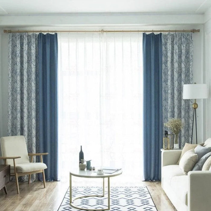 Rideaux élégants combinant des teintes bleues et motifs géométriques pour un salon moderne et lumineux. Ces tentures décoratives contrastent harmonieusement avec un mobilier minimaliste, apportant une touche de sophistication à l'espace de vie. Idéal pour créer une ambiance chic et accueillante.