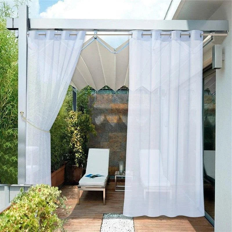 Voilage blanc pour terrasse extérieure, créant un espace ombragé élégant et moderne. Idéal pour une ambiance relaxante sur la terrasse avec fauteuil confortable et plantes vertes environnantes. Solution parfaite pour filtrer la lumière tout en préservant l'intimité.