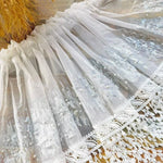 Voilage décoratif blanc avec sequins scintillants et bordure en dentelle, idéal pour habiller vos fenêtres avec élégance et sophistication. Parfait pour ajouter une touche de brillance à votre intérieur, tout en préservant la luminosité de votre pièce. Convient aux salons et chambres.