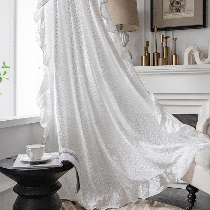 Voilage blanc élégant pour salon moderne, drapé près de la fenêtre pour filtrer la lumière naturelle, avec finitions à volants. Idéal pour un décor intérieur raffiné, ce rideau offre une touche de sophistication à votre espace de vie. Accessoire essentiel pour une ambiance lumineuse et confortable.