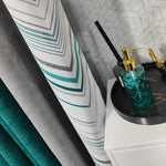 Décoration moderne et élégante pour la maison incluant des rideaux aux motifs géométriques en plusieurs nuances de gris et vert. Le distributeur de savon en verre avec un design texturé complète l'ensemble décoratif. Styling d'intérieur contemporain avec des éléments harmonieux pour un espace raffiné et accueillant. Idées de décoration tendance pour un salon ou une salle de bain.