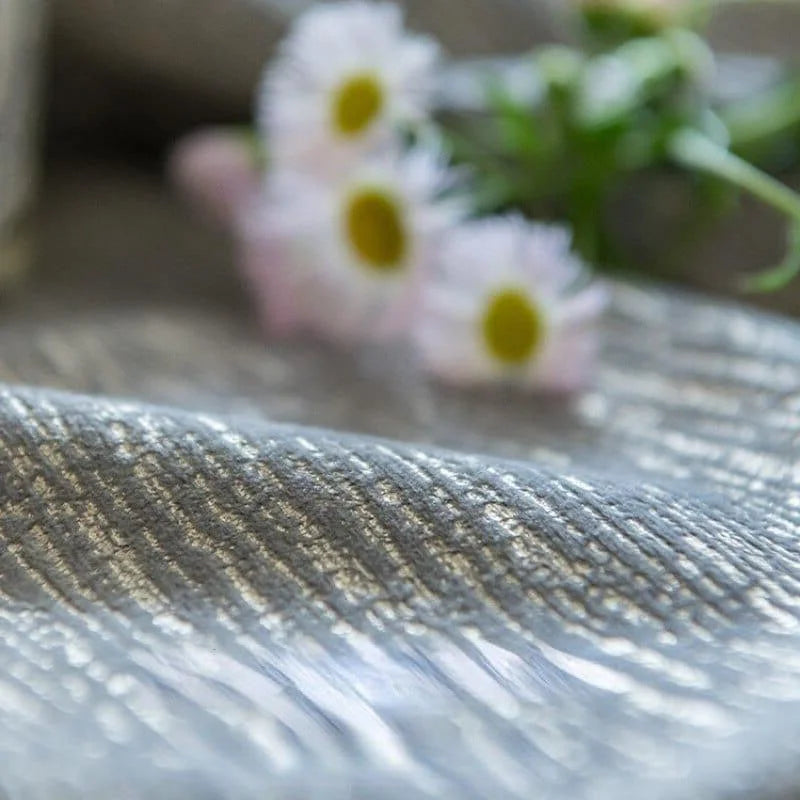 Tissu scintillant argenté avec une texture délicate et élégante, idéal pour la décoration intérieure et les projets de couture créatifs. Arrière-plan floral ajoutant une touche de douceur et de raffinement. Parfait pour apporter une ambiance chic et moderne à votre espace.
