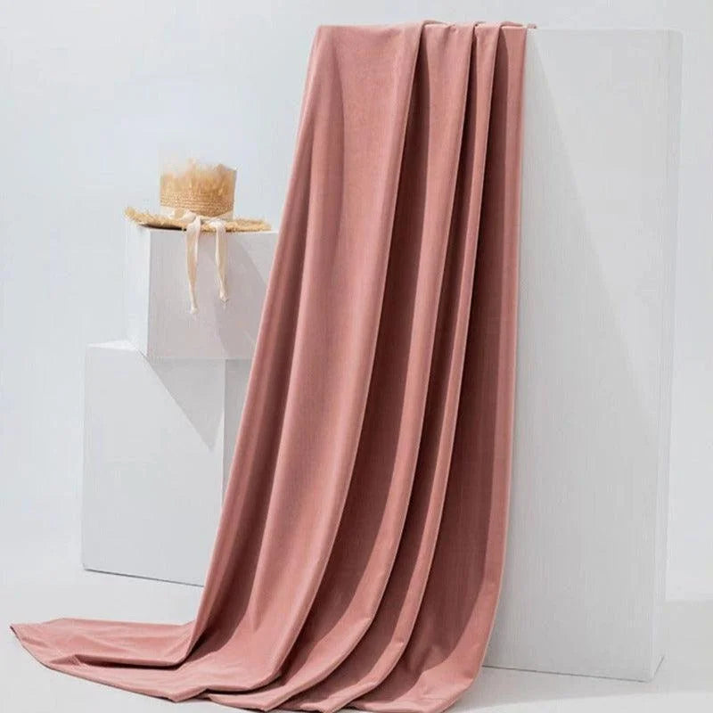 Drapé élégant rose posé sur un support blanc, ajoutant une touche de sophistication et de modernité à tout espace intérieur. Accessoirisé d'un chapeau élégant, idéal pour une décoration tendance et raffinée.