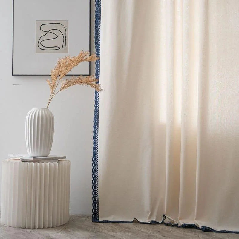 Rideau beige élégant avec bordure bleue, idéal pour un salon moderne. Décorez votre intérieur avec goût grâce à ce design subtil. Associez-le à une table basse blanche et un vase décoratif pour créer une ambiance apaisante et contemporaine. Parfait pour ceux qui cherchent à améliorer leur décoration intérieure avec des éléments esthétiques et fonctionnels.