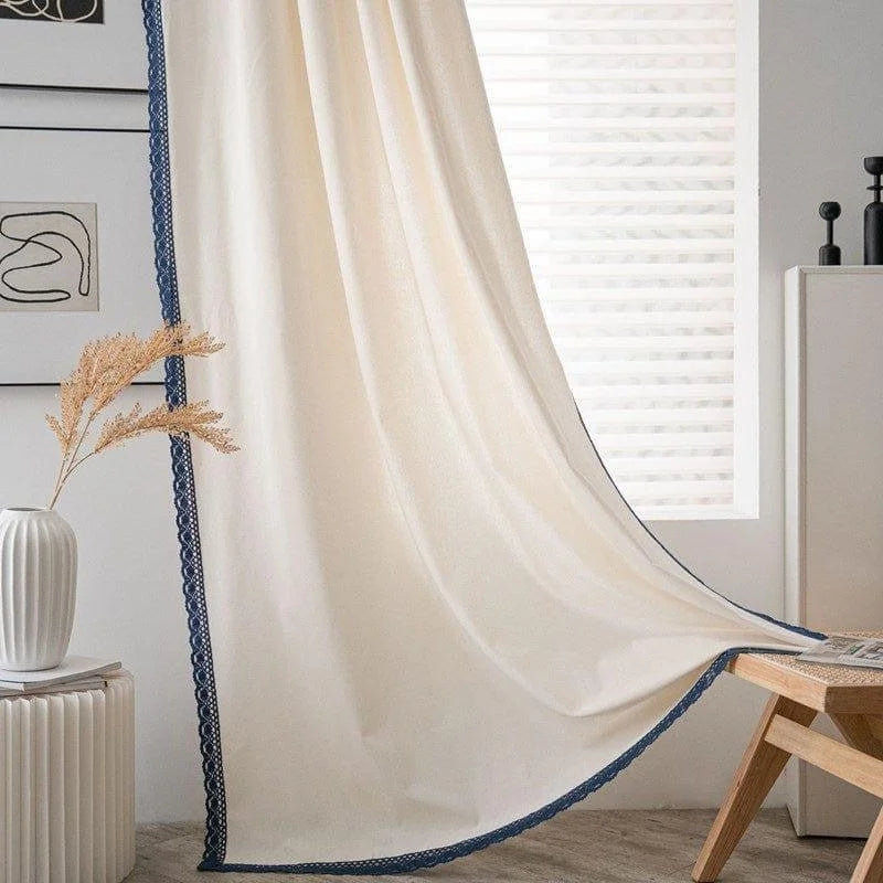 Rideau moderne de couleur beige avec bordure décorative bleue, idéal pour un salon contemporain. Apporte élégance et luminosité à votre intérieur grâce à son style épuré. Accessoire déco parfait pour créer une ambiance chaleureuse et accueillante dans votre maison.