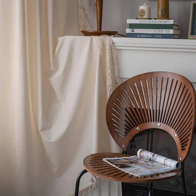 Chaise design moderne devant une cheminée élégante dans un intérieur élégant. Ambiance cosy avec des livres sur la cheminée et rideaux en arrière-plan. Accessoires décoratifs contemporains pour un salon tendance.