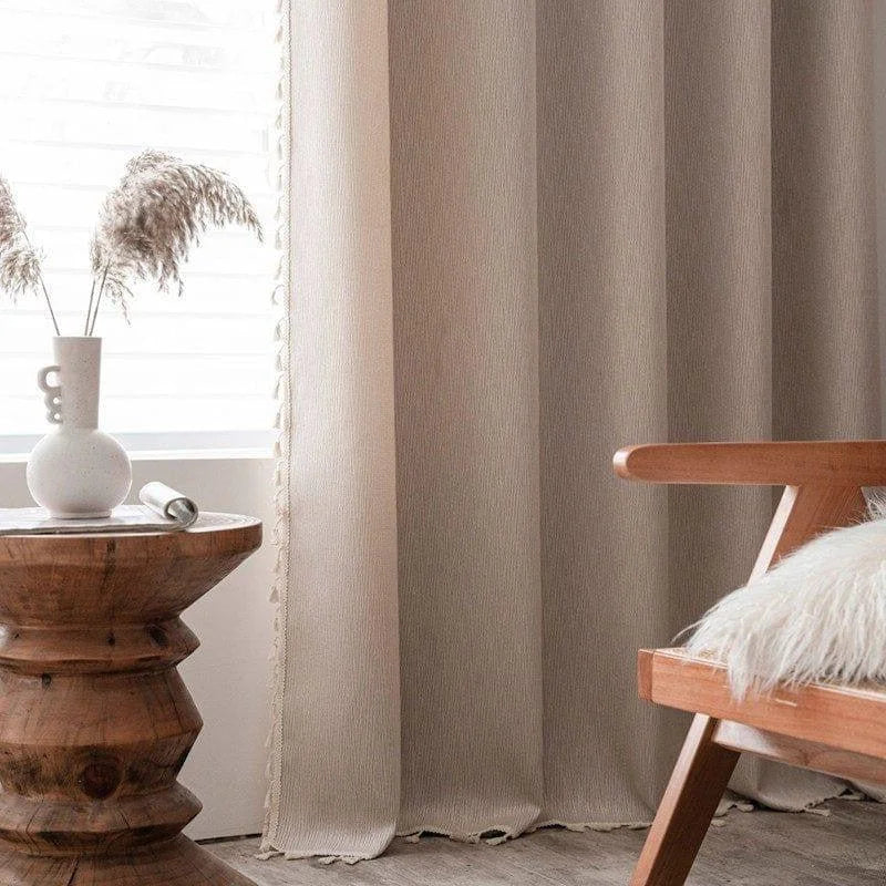 Rideaux élégants beige clair dans une décoration intérieure moderne avec une table d'appoint en bois sculpté. Le cadre chaleureux est enrichi par un fauteuil design et un vase déco, apportant une ambiance cosy et naturelle à votre salon. Parfaits pour filtrer la lumière tout en ajoutant une touche chic et accueillante à votre espace.
