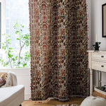 Rideau élégant avec motifs géométriques colorés, parfait pour apporter une touche ethnique à votre salon. Ce rideau décoratif, placé près d'une fenêtre lumineuse, apporte chaleur et style à votre intérieur. Idéal pour un aménagement de séjour moderne et cosy.