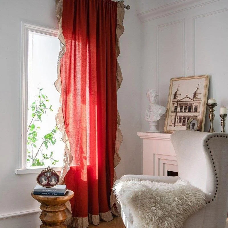 Rideau rouge élégant bordé de volants décoratifs transformant un salon sophistiqué, parfait pour ajouter une touche de chaleur et de couleur à votre espace intérieur. Ce rideau complète harmonieusement une décoration raffinée avec des éléments classiques comme un fauteuil confortable et un décor artistique. Parfait pour un aménagement intérieur chic et accueillant.