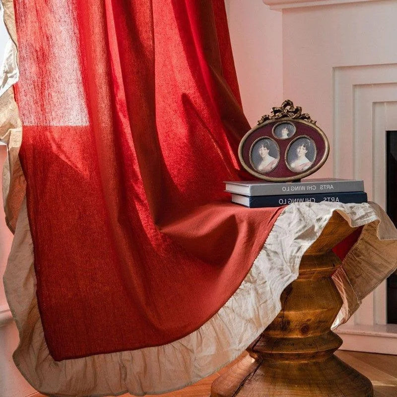 Rideau élégant rouge avec bordure beige, drapé sur une table en bois sculptée. Parfait pour ajouter une touche de chaleur et de sophistication à votre intérieur, idéal pour le salon ou la chambre.
