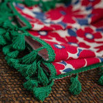 Châle coloré avec motifs floraux rouges et bleus et franges vertes, idéal pour ajouter une touche de couleur et d'élégance à votre tenue. Accessoire parfait pour une utilisation quotidienne ou pour des occasions spéciales.
