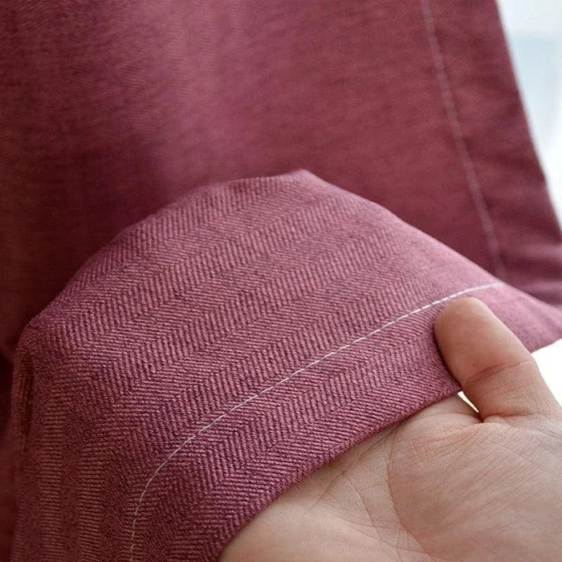 Vue détaillée d'un tissu élégant de couleur rose, mettant en valeur un motif à chevrons subtil. Le produit présente une finition soignée avec des coutures délicates, idéal pour ajouter une touche de sophistication à n'importe quel intérieur moderne. Ce tissu raffiné est parfait pour la conception de rideaux ou de revêtements décoratifs.